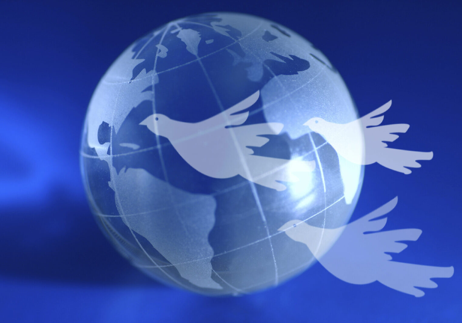 Global Peace A blue globe with doves flying ahead. A global peace idea.